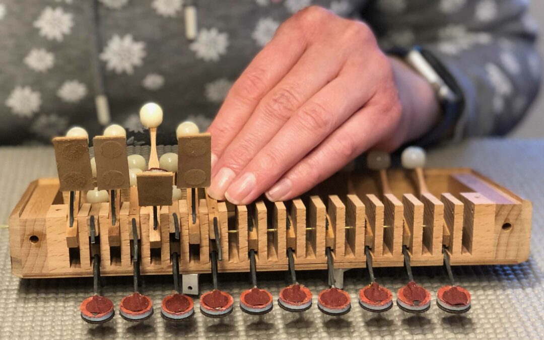 Reparatur einer Diskant Tastatur eines Wylaender-Oergeli. Neue Achsen werden am Schwyzerörgeli ausgetauscht.